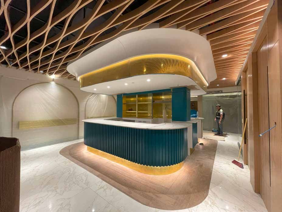 Recepción con barra curva iluminada y plafón reticulado de madera, fabricados por taller101